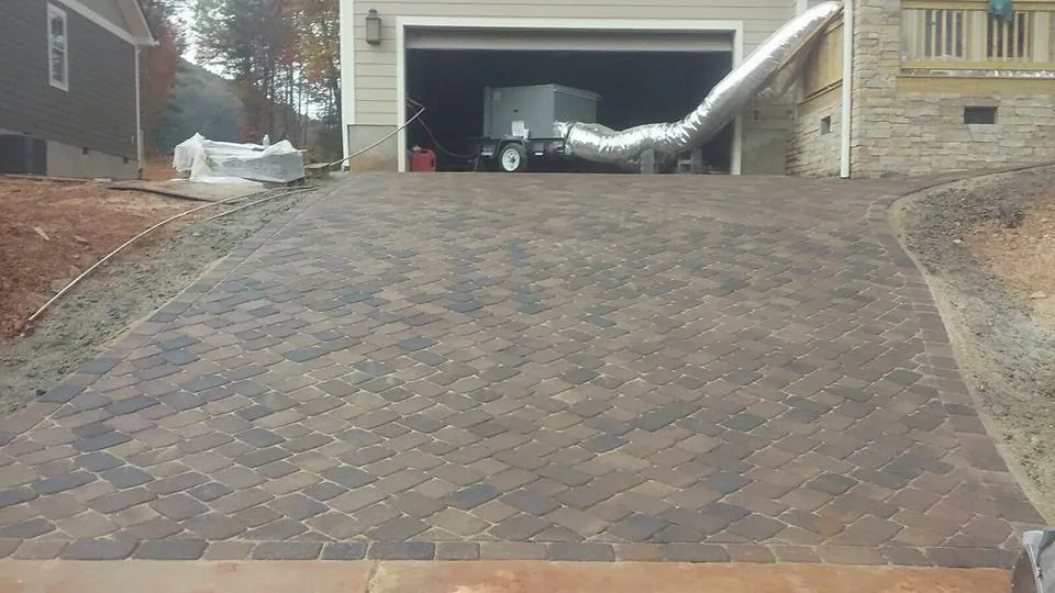Paver driveway under construction, temporary equipment staged in the garage